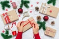 Female hands wrapping Christmas present. Festive holiday preparation with woman hands, gift boxes, baubles, decoration Royalty Free Stock Photo