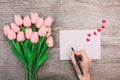 Female hands write a message of love on a white envelope, on a wooden background. Valentine`s Day Royalty Free Stock Photo