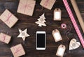Smart phone with christmas presents on wooden background top view. Online holiday shopping concept. Flat lay, text space. Internet Royalty Free Stock Photo