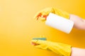 female hands in yellow rubber gloves hold a soap dispenser and a sponge for washing dishes and cleaning Royalty Free Stock Photo