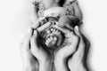 Female hands of young mother holding her newborn baby feet, closeup image with blur baby in background Royalty Free Stock Photo