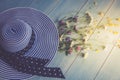 Female hat, striped, bouquet of wildflowers, top view. On a wooden background. Blue color. Conceptual image. Royalty Free Stock Photo