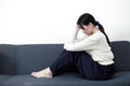 Female having depression sitting alone on sofa. woman headache unhappy emotion. young anxiety despairing mental health problems