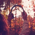 Female with headphones walking on the park listen sounds or music of autumn forest. Concept. Indian summer