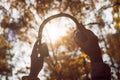 Female with headphones walking on the park listen sounds or music of autumn forest. Concept. Indian summer