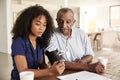 Female healthcare worker checking the blood pressure of a senior man during a home visit Royalty Free Stock Photo