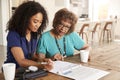 Female healthcare worker filling in a form with a senior woman during a home health visit Royalty Free Stock Photo