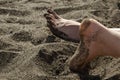 Female heel on the black sand on the beach. Royalty Free Stock Photo