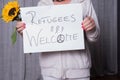Female helper welcomes refugees with sunflower Royalty Free Stock Photo