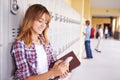 Female High School Student By Lockers Using Mobile Phone Royalty Free Stock Photo