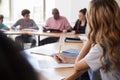 Female High School Student Writing Notes Whilst Sitting At Desk In Class Royalty Free Stock Photo