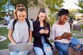 Female High School Students Using Digital Devices Outdoors During Recess