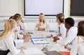 Female High School Teacher Sitting At Table With Teenage Pupils Wearing Uniform Teaching Lesson Royalty Free Stock Photo