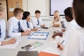 Female High School Teacher Sitting At Table With Teenage Pupils Wearing Uniform Teaching Lesson Royalty Free Stock Photo