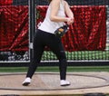 Female high school track and field athlete in the circle throwing a wieght during a weight throw competition Royalty Free Stock Photo