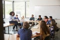 Female High School Tutor Sitting At Table With Pupils Teaching Maths Class Royalty Free Stock Photo