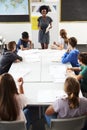 Female High School Tutor Standing By Table With Students Teaching Lesson Royalty Free Stock Photo