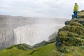 Female hiker admiring Dettifoss waterfall.