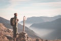 Female hiker with backpack looking at the majestic view on the italian Alps. Mist and fog in the valley below, snowcapped mountain Royalty Free Stock Photo