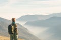 Female hiker with backpack looking at the majestic view on the italian Alps. Mist and fog in the valley below, snowcapped mountain Royalty Free Stock Photo