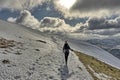 Female hiker descending a snow covered Helvellyn Royalty Free Stock Photo