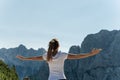 Female hiker enjoying life standing with arms wide open enjoying the view of the Alps