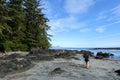 A female hiker exploring the sandy beaches of nels bight and experimental bight, surrounded by forest and the pacific ocean