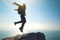 Hiker jumping on sunrise seaside cliff edge Royalty Free Stock Photo