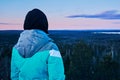 Female hiker looking from mountain at cold morning winter forest landscape Royalty Free Stock Photo