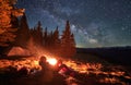Hiker near bonfire admire beauty of stunning starry sky