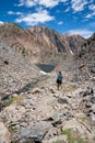 A female hiker makes her way down a dangerous hiking path of talus and rock scree