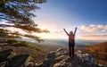 Female Hiker Raising Arms to the sun setting over a beautiful vista at the top of an Appalachian mountain