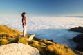 Female hiker reaching her goal at the mountain top and looking at majestic panoramic view of the italian western Alps with clouds