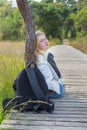 Female hiker sitting on wooden path in nature