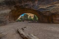 Female hiker stading in Navajo Arch at beautiful summer day near