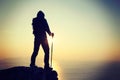 Female hiker standing on sunrise seaside cliff edge Royalty Free Stock Photo