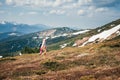 Female hiker in a unicorn costume in mountains in Spring