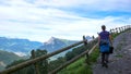 Female hiker walking along a country road with a great view of a mountain landscape Royalty Free Stock Photo