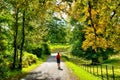 Female hiker walking through early Autumn woodland