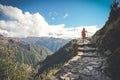 A female hiker is walking on the famous Inca trail of Peru with walking sticks. She is on the way to Machu Picchu