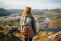 Female hiker wearing casual clothes admiring a scenic view from a mountain top. Adventurous young girl with a backpack. Hiking and