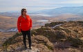 Female hikers stands atop of mountain summit