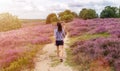 A female hiking along heather covered hills