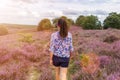 A female hiking along heather covered hills