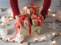 Female holding Christmas gift boxes over Christmas ornament and lights