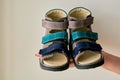 Female is holding close-up a special children`s orthopedic shoe sandals made of genuine leather.