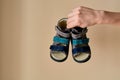 Female is holding close-up a special children`s orthopedic shoe sandals made of genuine leather.