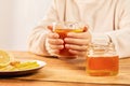 Female holding a cup of hot tea with citrus, ginger and honey - home treatment Royalty Free Stock Photo