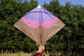 Female holding and flying a big kite with nature background on occasion of Indian kite flying festival of Makar sankranti or Royalty Free Stock Photo