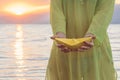 Female holding paper boat on the beach at sunset Royalty Free Stock Photo
